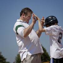 Ann Arbor resident Howard Bunsis claps hands with his son Josh after making it to first base during the Challenger League baseball game Sunday afternoon at Dexter High School. The Challenger League, a league for children with special needs, was accompanied by the Dexter High School baseball team. Jeffrey Smith | AnnArbor.com 
